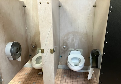 Two bathroom stalls in a high school.